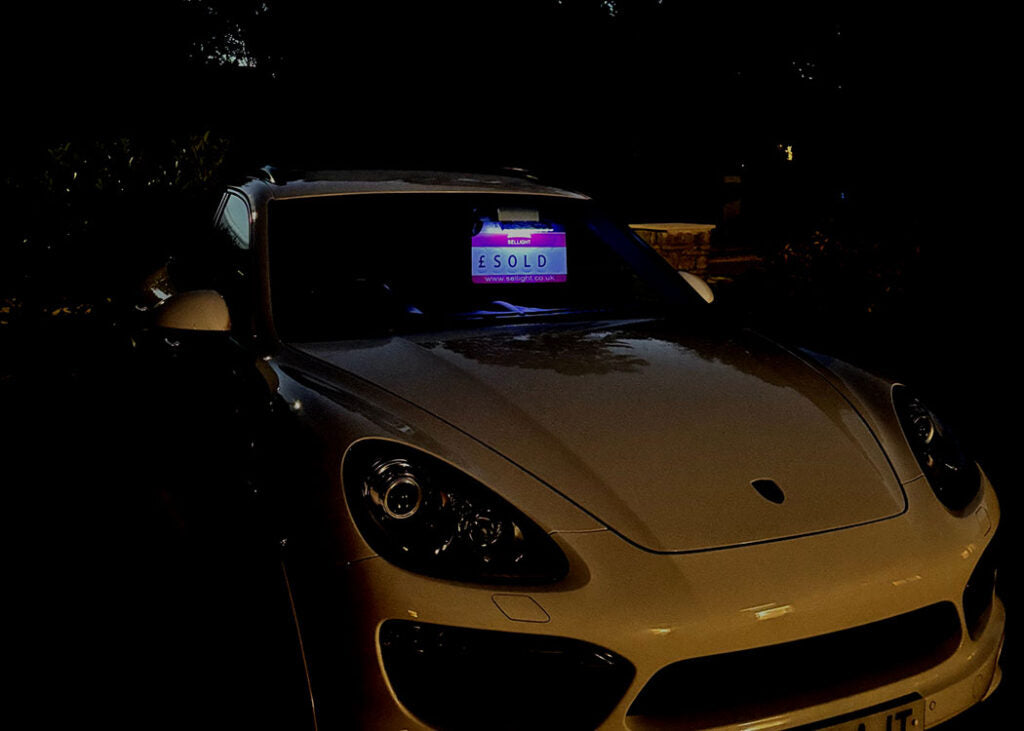 Car with a screen displaying 'SOLD' in a dark setting