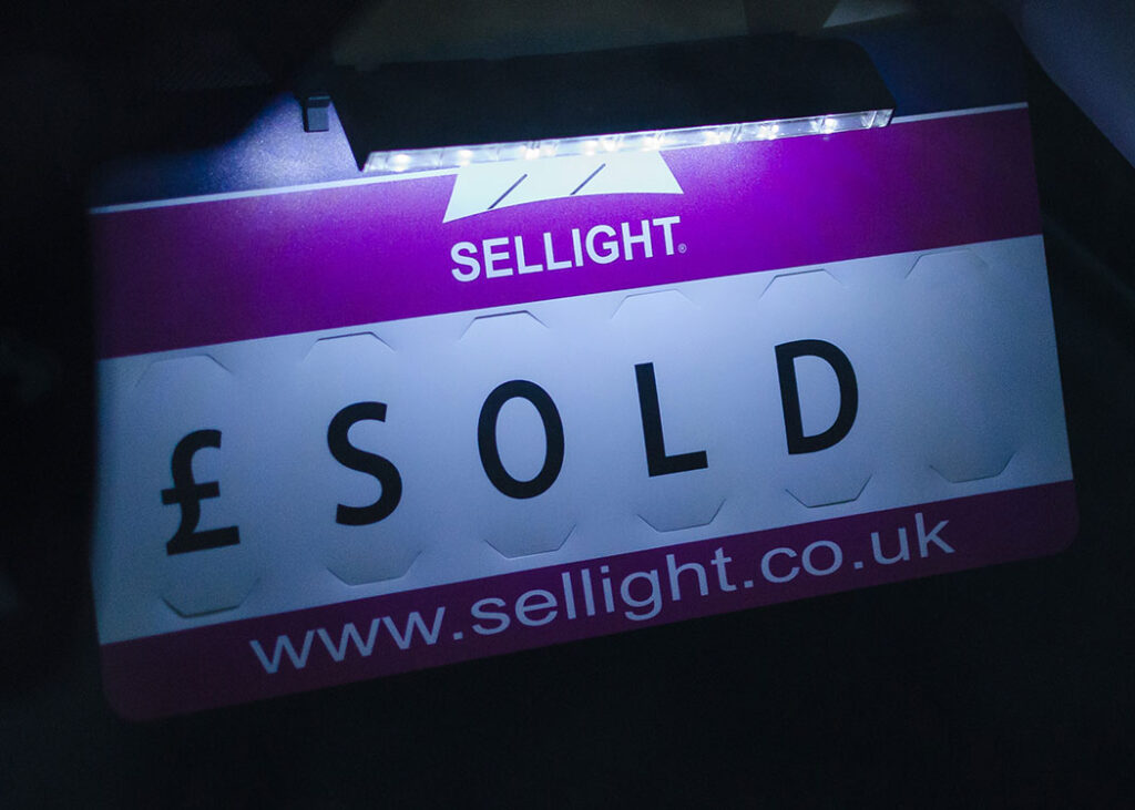 Sellight brand name on a sign with 'SOLD' text and website URL.